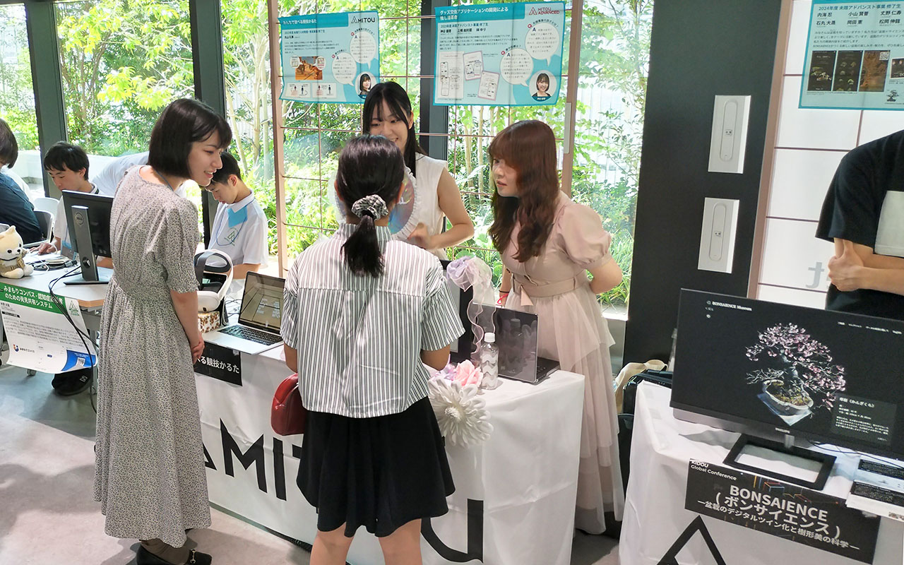 修了生がブースで説明している様子