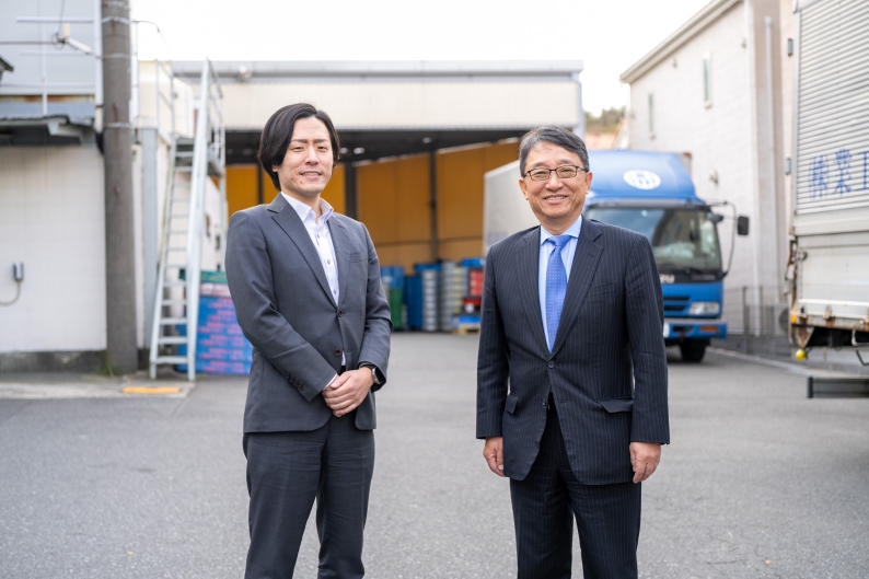 写真：工場バックに岡田社長、岡田生産本部長二人の写真